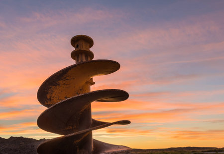 One large post drill bit at sunset.の写真素材