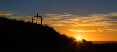 Three cross on a sand hill as the sunsets.の写真素材