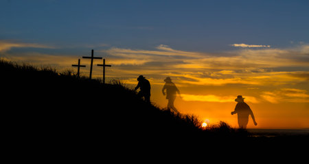 Cowboy hated man walking to three cross hill as the sunsets.の写真素材