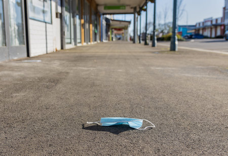 Covert-19 face mask left at a empty town main street because of Covert-19 lockdown.
