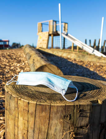 Covert-19 face mask left at a empty playground because of Covert-19 lockdown.の写真素材