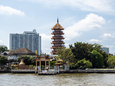 The Chee Chin Khor Temple, a beacon of Chinese culture and spirituality, rises majestically from the banks of the Chao Phraya River in Bangkok. Its ornate facade and colorful rooftops are a testament to the enduring legacy of Chinese immigrants in Thailand, and a stunning sight to behold from the water.の写真素材