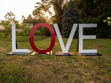 A white and red Love sign located on a grass lawn with direct sunlight in Front Royal, Virginia, USA.の写真素材