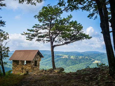 Nestled within the picturesque Cranny Crow Overlook in Lost River State Park, West Virginia, a charming small hut stands beside a resilient pine tree. Against the stunning backdrop of the rolling landscape, this rustic scene encapsulates the tranquility and natural allure of the Appalachian wilderness.の写真素材
