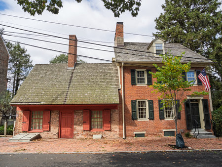 The two-part facade of the Dutch House Museum, a historic brick residence with dark green shutters, in New Castle, Delaware.の写真素材
