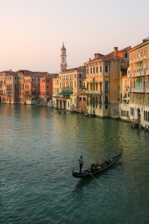 Vertical oriented image of gondola sailing on Gand Canal along old multicolored houses in Venice, Italy.の写真素材