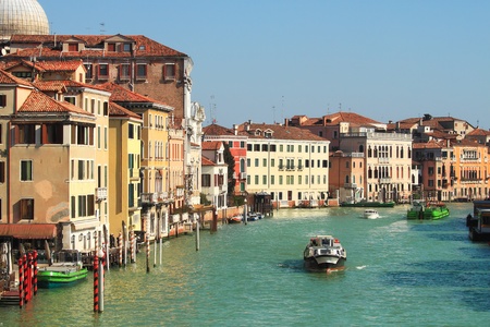 View on motor boat on city canal passing by old historic multicolored houses in Venice, Italy.の写真素材