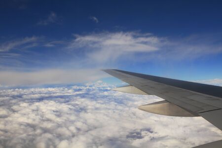 Aerial view on clouds and blue sky from airplane.の写真素材