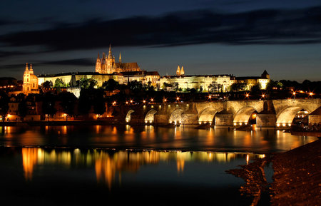 View on famous Charles Bridge and Castle illuminated at evening in Prague, Czech Republic.のeditorial素材
