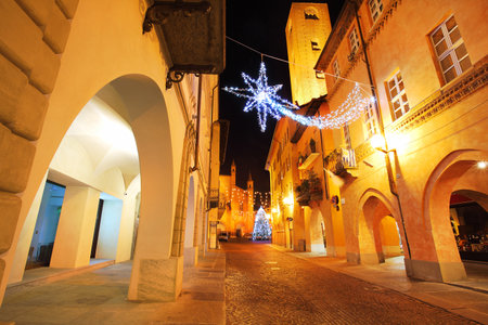 Alba old town central street with illuminations and Christmas Tree against San Lorenzo Cathedral on the background in Italy.のeditorial素材