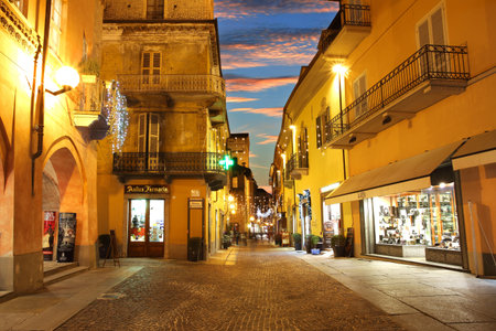 ALBA - DECEMBER 07: Popular touristic  historic street with opened shops, bars and stores and illuminations for Christmas and New Year holidays under beautiful evening sky on December 07, 2011 in town of Alba, Northern Italy.のeditorial素材