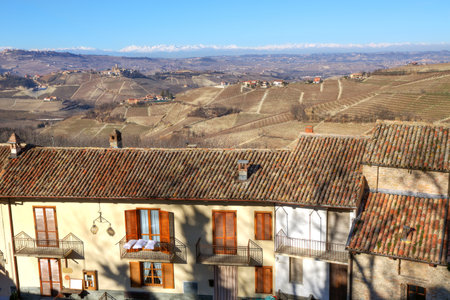 View over the house roof on hills of Piedmont and Alps with snowy peaks on the background in Northern Italy.のeditorial素材