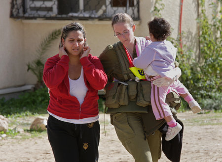 ASHKELON - JANUARY 10: An israeli soldier from the rescue team holds young girl who was witness of missile launched by Hamas terrorists from Gaza explode near her house on January 10, 2009 in Ahskelon, Israel.のeditorial素材