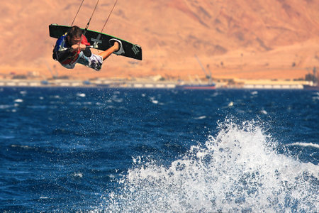 EILAT, ISRAEL - MARCH 31: Unidentified kitesurfer jumps over the water during surfing on Red Sea March 31, 2010 in Eilat, Israel.のeditorial素材