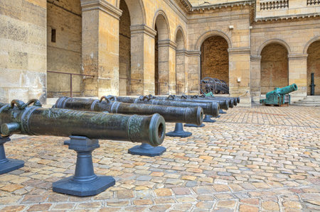 Ancient cannons stand in the row on cobbled yard in museum at Les Invalides in Paris, France のeditorial素材