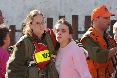 ASHKELON - JANUARY 10: An israeli soldier from the rescue team holds and hugs young girl who was witness of missile launched by Hamas terrorists from Gaza explode near her house on January 10, 2009 in Ahskelon, Israel.のeditorial素材