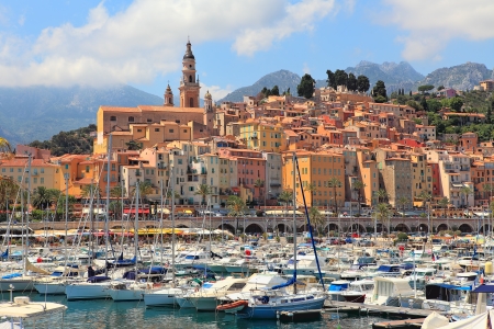 View on colorful houses, church and marina with yachts and boats in Menton - town on French Riviera in France の写真素材