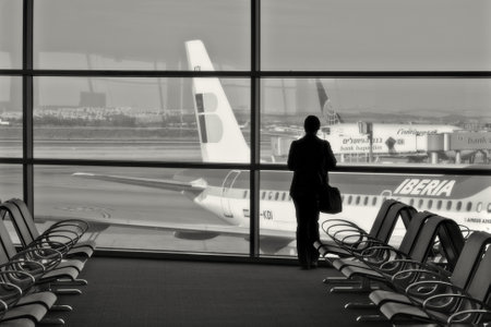TEL AVIV - MAY 08: Unidentified person standing against big window in the terminal of Ben Gurion International Airport and looking at airplanes at the gates on May 08, 2008 in Tel Aviv, Israel.のeditorial素材