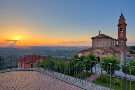 Old church on small plaza and hills of Langhe on background at sunset in town of Diano Dの写真素材