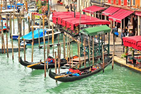 VENICE - NOVEMBER 13: View from Rialto Bridge on Grand Canal, gondolas and promenade with bars and restaurants - one of the most popular places among tourists in Venice, Italy on November 13, 2012.のeditorial素材