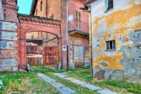 Small courtyard at thr entrance to old abandoned warehouse in small italian town の写真素材