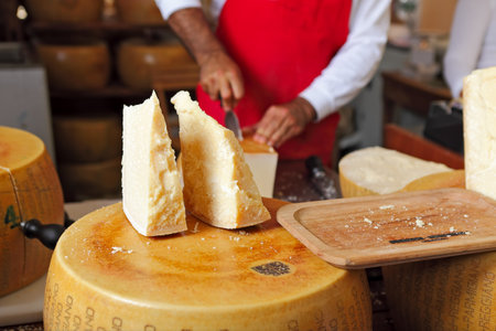 Two pieces of cheese on top of whole Parmesan wheel at International Cheese Festival in Bra, Northern Italy のeditorial素材