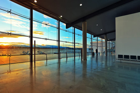 Departures hall and big window with beautiful view on airport field at sunset in Valencia, Spain 