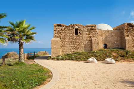 Promenade along Mediterranean sea coast with palms and ancient tomb of unknown shah in Ashkelon, Israel の写真素材