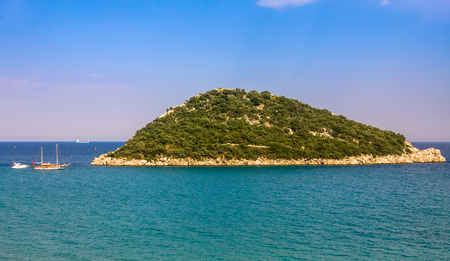 Small rocky island covered with trees in the bay between Antalya and Kemer - popular resorts on Mediterranean sea in Turkey の写真素材