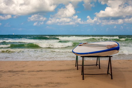 Lifeguard s board with paddles on the beach in front of waving Mediterranean sea の写真素材
