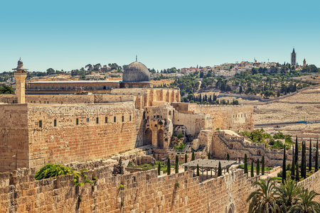 Minaret and dome of Al-Aqsa Mosque surrounded by ancient walls in Jerusalem, Israel.