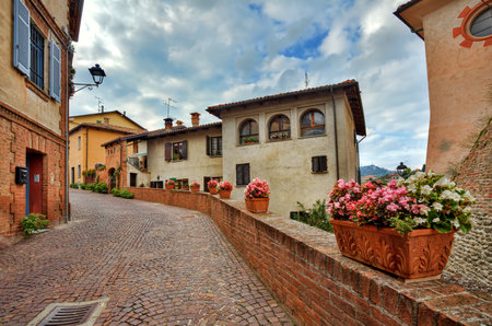 Narrow cobbled street among medieval colorful houses at town of Barolo in Piedmont, Northern Italy.のeditorial素材