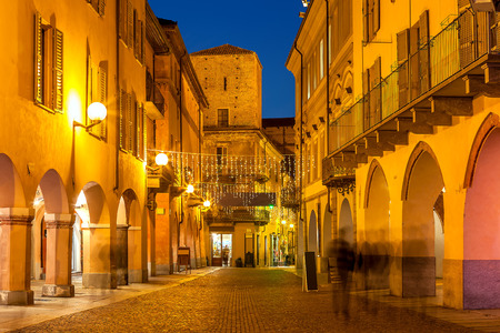 Silhouettes of people walking on evening streets of Alba in Piedmont, Northern Italy.の写真素材