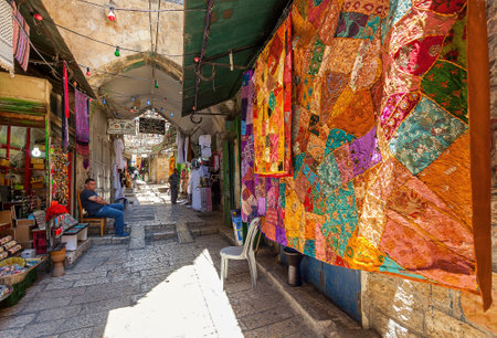 JERUSALEM, ISRAEL - JULY 10, 2014: Traditional colorful carpets on bazaar - famous market in Old City of Jerusalem, popular site for visiting among locals and tourists traveling to Holy Land.のeditorial素材