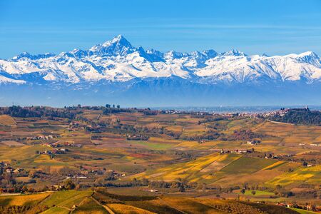 Autumnal hills and snowy mountain ridge on background in Piedmont, Northern Italy.の写真素材