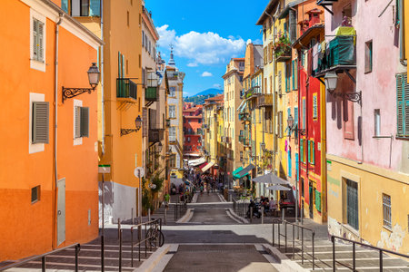 NICE, FRANCE - AUGUST 23, 2014: Narrow street in old tourist part of Nice - fifth most populous city and one of the most visited cities in France, receiving 4 million tourists every year.のeditorial素材