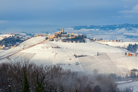 Small medieval town on snowy hill in winter in Piedmont, Northern Italy.の写真素材