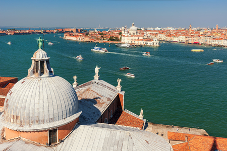 Domes of San Giorgio Maggiore church overlooking Grand canal and with boats and city skyline in Venice, Italy.の写真素材