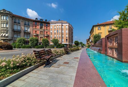 Four seasons modern fountain and pedestrian walkway with benches on piazza Ferrero - central town square in Alba, Piedmont, Northern Italy.の写真素材