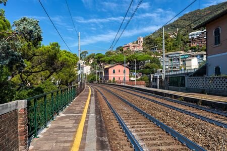 View of small empty outdoor railway station under blue sky in town of Recco in Liguria, Italy.の写真素材