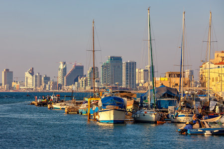 Yachts and boats moored in old port of Jaffa as modern buildings of Tel Aviv seen on background.のeditorial素材