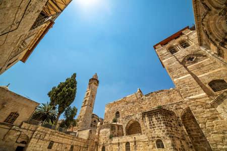 Exterior view of the Church of the Holy Sepulcher and minaret under blue sky in Old City of Jerusalem, Israel.の写真素材