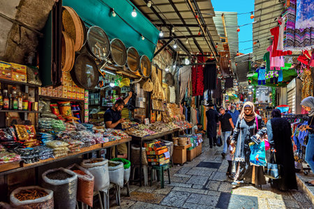 JERUSALEM, ISRAEL - JULY 14, 2019: People walking on narrow street with tipical shops on famous bazaar located in Old City of Jerusalem, popular place to visit with tourists and pilgrims.のeditorial素材