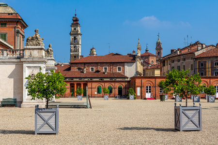 Old houses and churches under blue sky in historic center of Racconigi - town in Piedmont, Northern...
