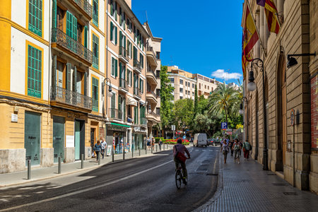 PALMA, SPAIN - MAY 10, 2019: People walking on narrow urban street among colorful buildings in Palma - capital of Balearic Islands, famous and popular tourist destination.のeditorial素材