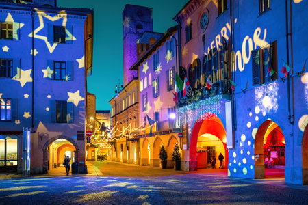 Town square and old historic buildings illuminated and decorated for Christmas holidays in historic town of Alba, Piedmont, Italy.の写真素材