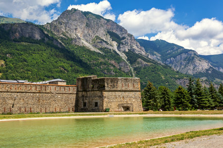 View of the small artificial lake, old military fortress and mountains on background in Italy.の写真素材
