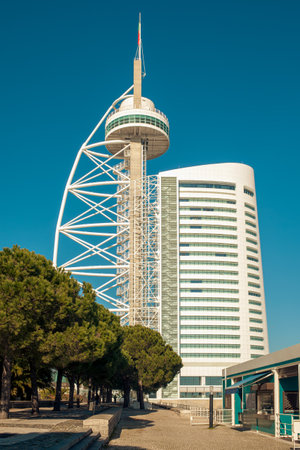Famous Vasco da Gama Tower and white modern hotel building under a blue sky in Lisbon, Portugal.の写真素材