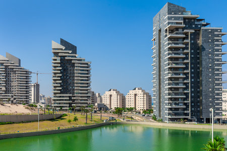 Small artificial lake and modern high-rise residential buildings under blue sky in the city of Ashdod, Israel.の写真素材