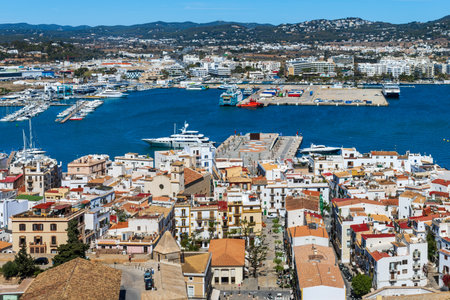 View from above on the white buildings with red and orange roofs and the port of Eivissa, Ibiza, Spain.の写真素材